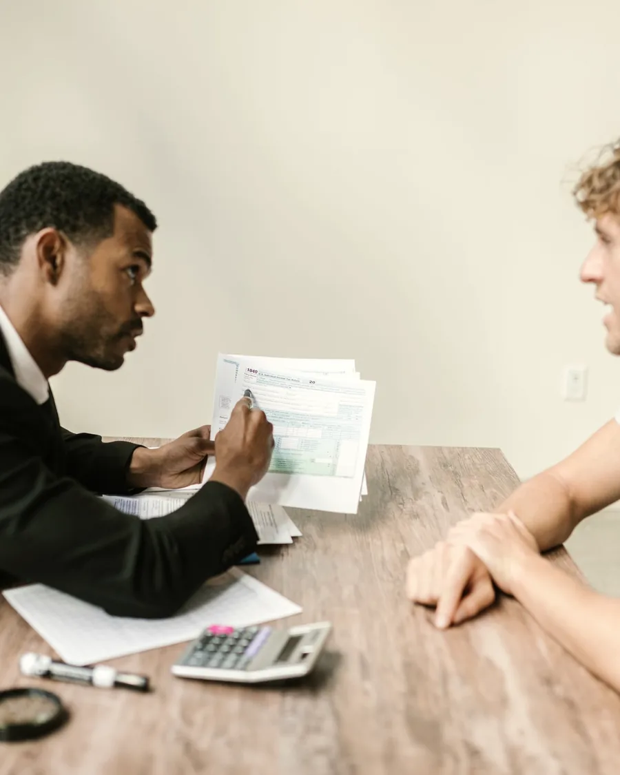An advisor going over paperwork with a client at a desk