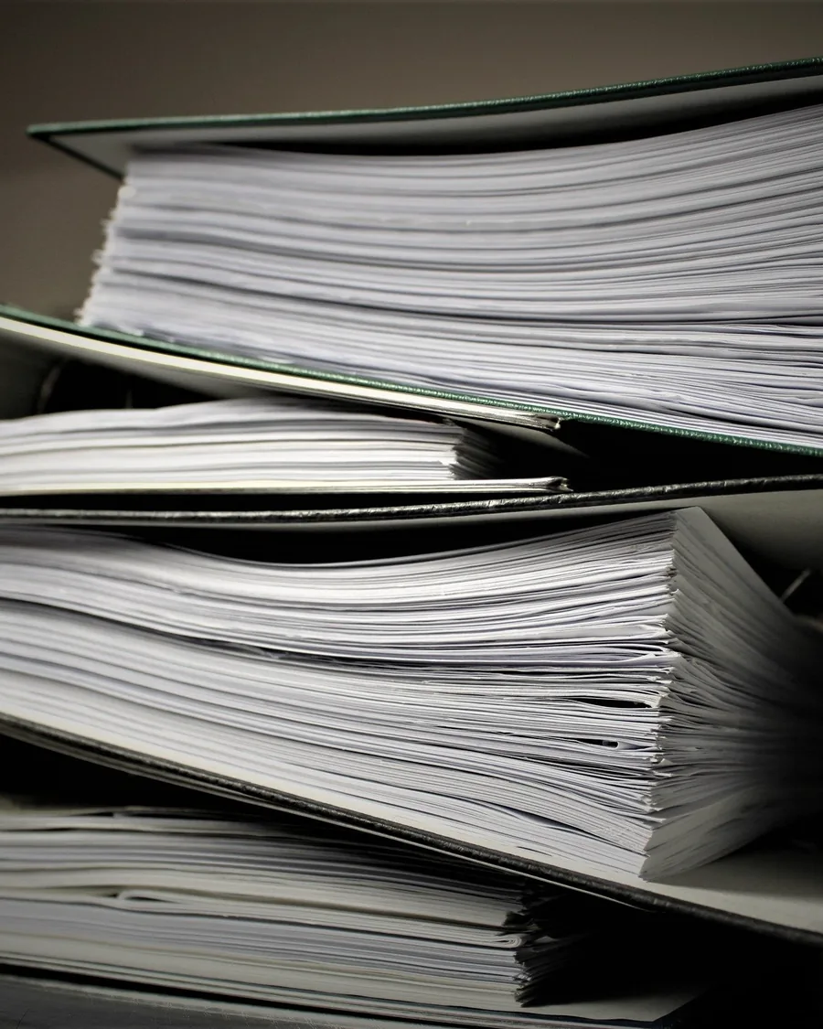 Thick binders of closed files stacked on top of one another