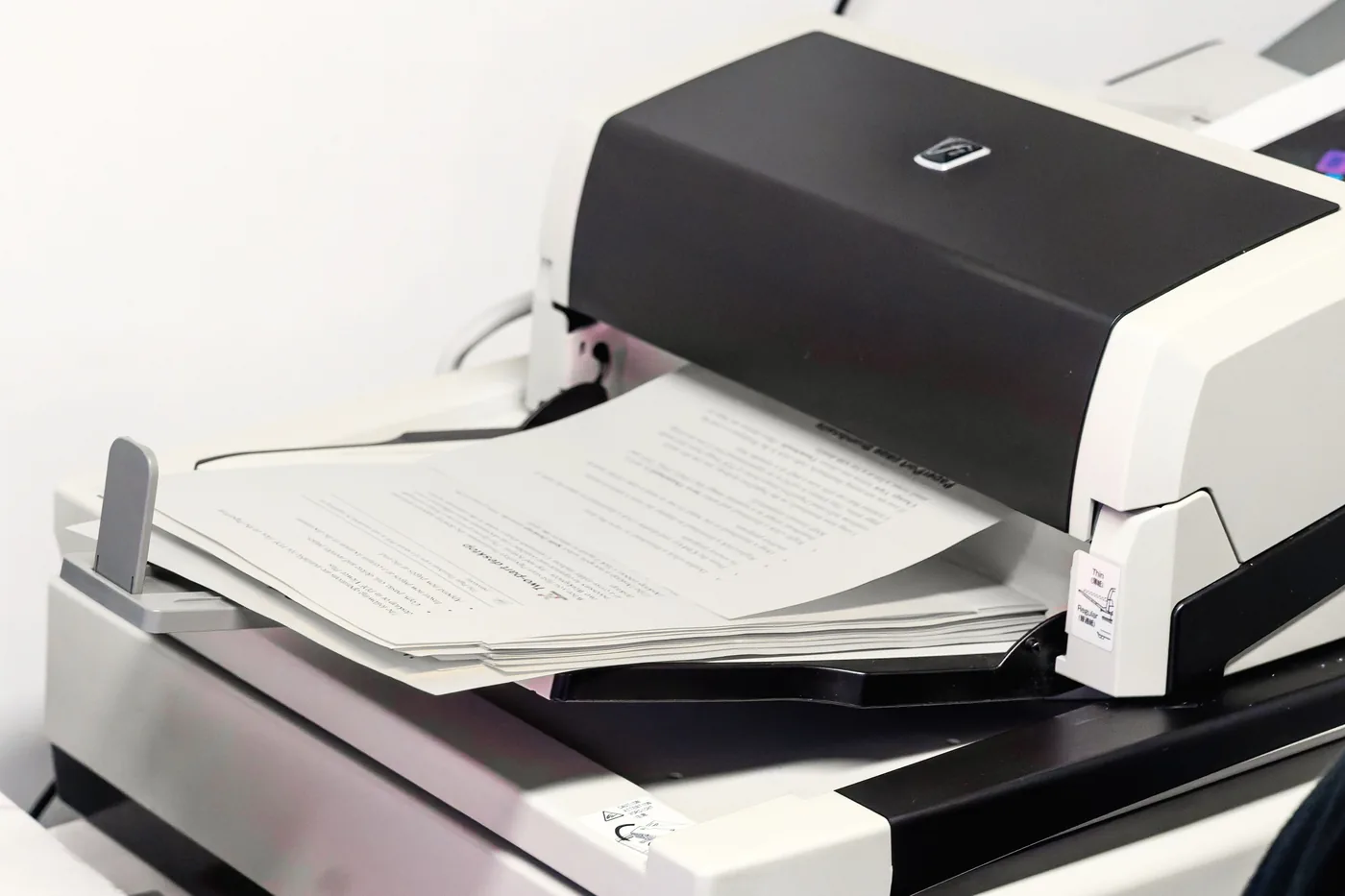 Une pile de pages qui entre dans un numériseur de production