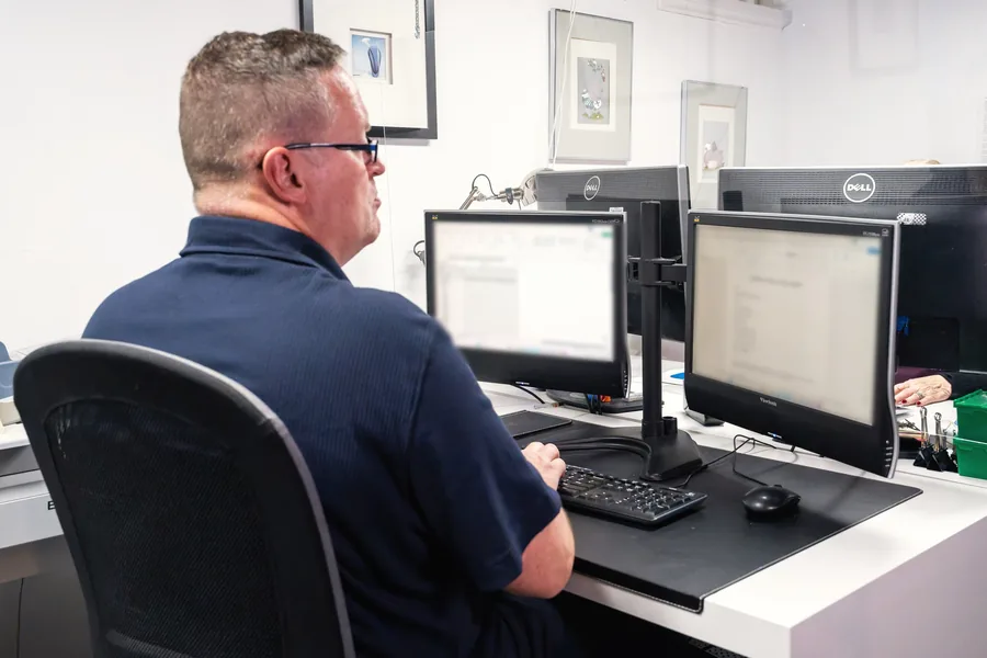 A member of our credentialed staff at work at a dual-monitor workstation